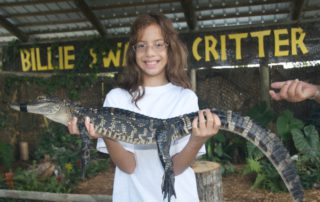Girl holding a gator.