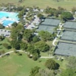 Aerial view of tennis courts and outdoor pools.