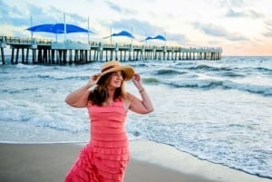 Photo of a Smiling Woman Walking Along Sandy Pompano Beach. Work and Travel Comes Naturally Here.