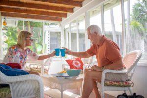 A couple enjoying a drink in Cottages by the Ocean's screened in porch
