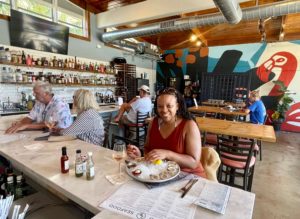 A woman enjoying a oysters at Flamingo Seafood, one of Pompano Beach's newest restaurants