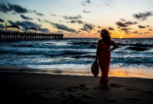 A woman standing near Pompano Beach Fishing Pier during sunrise