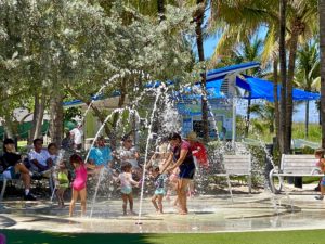 A family splashing in a fountain in Pompano Beach, Florida