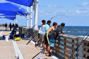 Men at a fishing pier in Pompano Beach, Florida, on a spring vacation